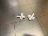 The 3D printed prototypes of the replacement for the black piece of plastic.