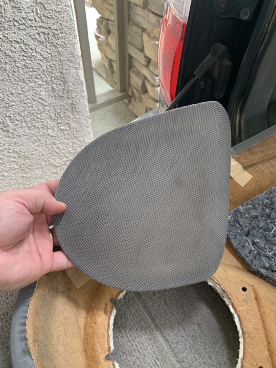 A speaker grill with its dirty cloth covering.